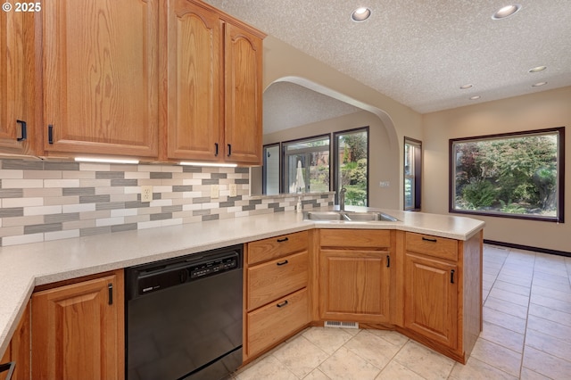 16402 SE Teal Ct, Damascus, OR 97089 - kitchen with black dishwasher, a sink, a peninsula, arched walkways, and decorative backsplash