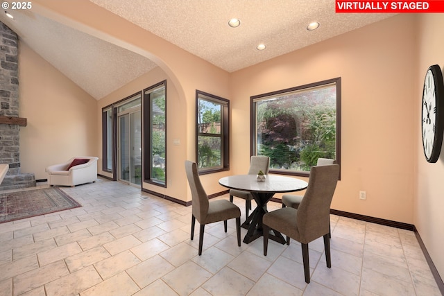 16402 SE Teal Ct, Damascus, OR 97089 - dining area with arched walkways, a textured ceiling, recessed lighting, baseboards, and lofted ceiling