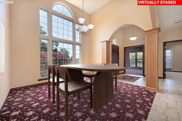 16402 SE Teal Ct, Damascus, OR 97089 - dining area featuring ornate columns, arched walkways, a textured ceiling, high vaulted ceiling, and baseboards