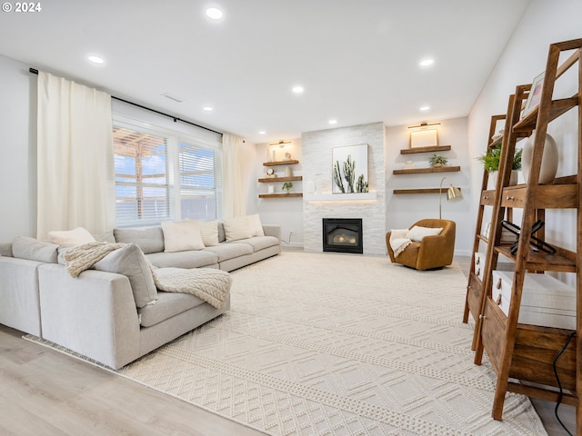 living room with light hardwood / wood-style floors and a large fireplace