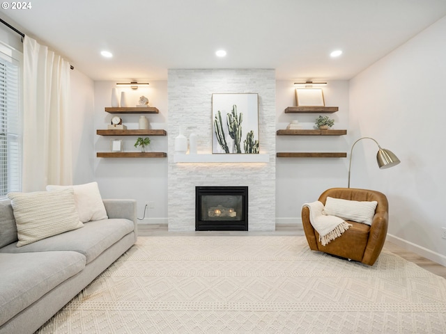 living room with a large fireplace and wood-type flooring