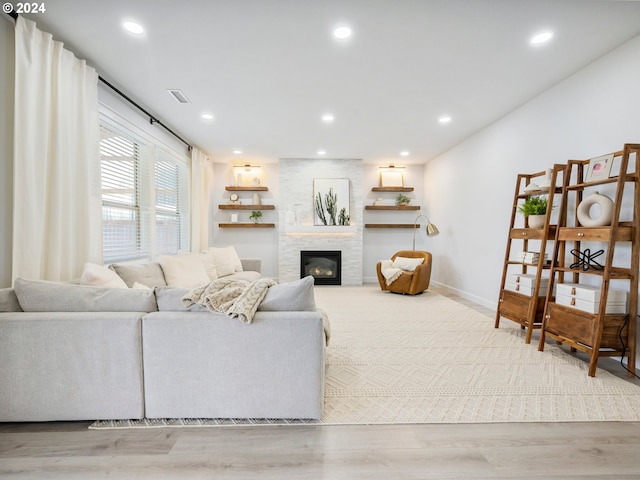 living room featuring hardwood / wood-style flooring and a large fireplace