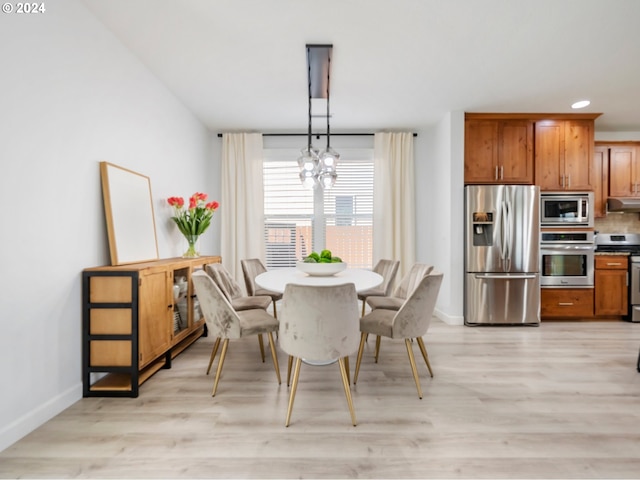 dining area featuring a notable chandelier and light hardwood / wood-style floors