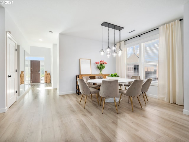 dining space featuring an inviting chandelier and light hardwood / wood-style floors