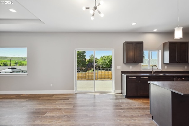 365 NW 4th St, Dufur, OR 97021 - kitchen with a sink, dark brown cabinetry, a chandelier, recessed lighting, and light wood-style floors
