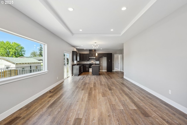 365 NW 4th St, Dufur, OR 97021 - unfurnished living room with wood finished floors, recessed lighting, baseboards, a raised ceiling, and a sink