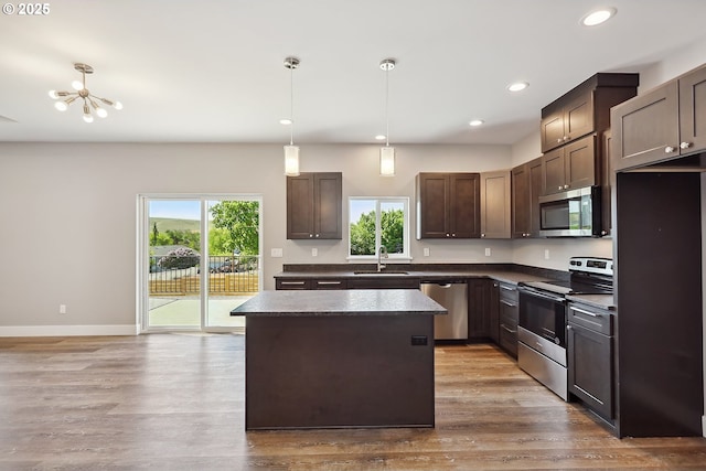 365 NW 4th St, Dufur, OR 97021 - kitchen with appliances with stainless steel finishes, dark countertops, a sink, dark brown cabinetry, and a kitchen island