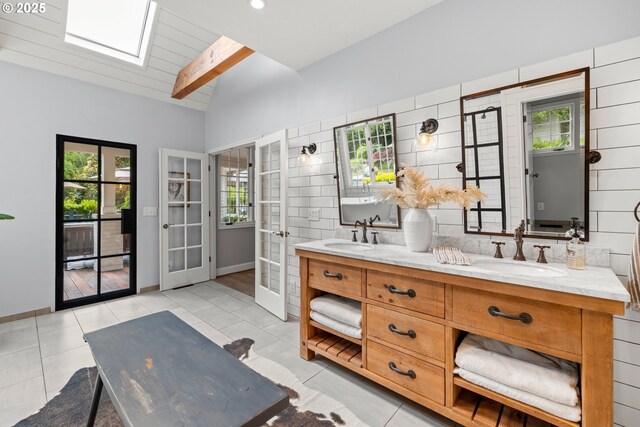 21424 SW 65th Ave, Tualatin, OR 97062 - bathroom featuring vaulted ceiling, double vanity, french doors, a skylight, and plenty of natural light