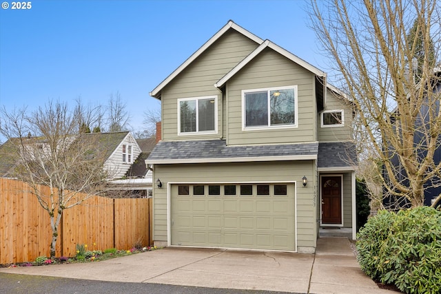 traditional-style house with driveway, a shingled roof, a garage, and fence