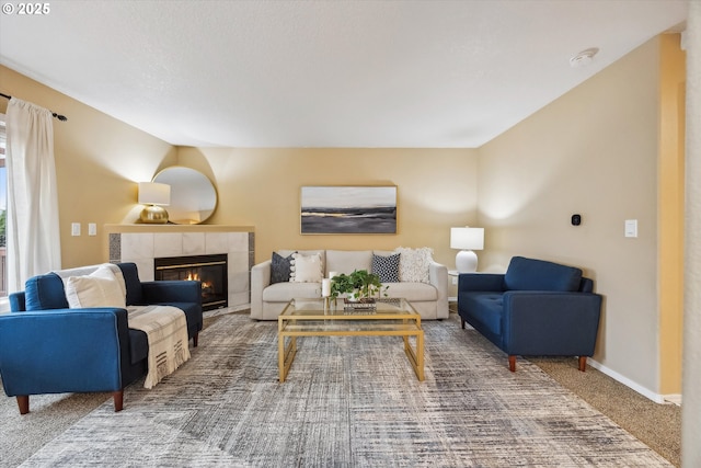 living area featuring baseboards, carpet, and a tiled fireplace