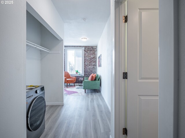 bedroom with multiple windows, wood-type flooring, and brick wall