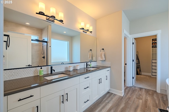 10107 NE 136th Ave, Vancouver, WA 98682 - bathroom with double vanity, wood finished floors, tasteful backsplash, a walk in closet, and a stall shower