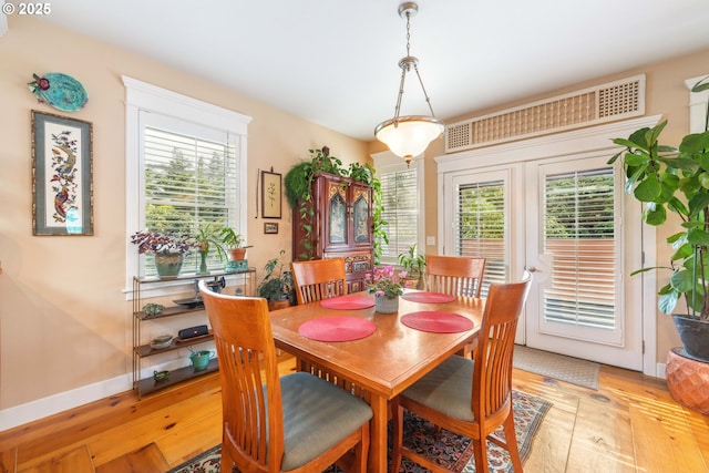 dining space with baseboards and light wood-type flooring