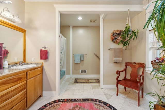 bathroom with a shower with shower curtain, vanity, visible vents, and baseboards