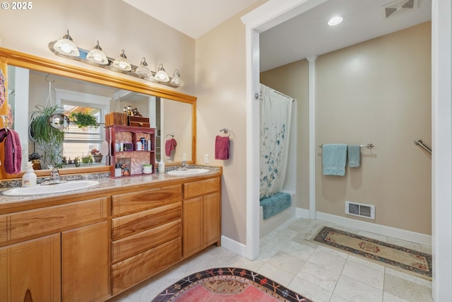 bathroom with double vanity, a sink, and visible vents
