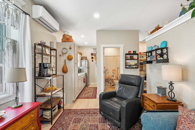sitting room featuring recessed lighting, light wood-style floors, and a wall unit AC