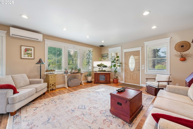 living room featuring a wall mounted AC, wood finished floors, recessed lighting, and a wealth of natural light