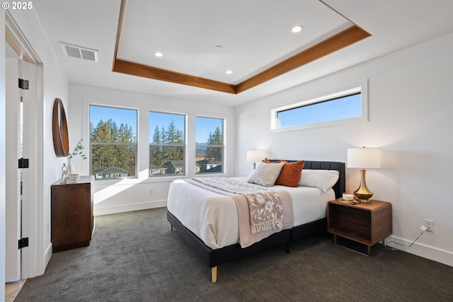 bedroom with carpet floors, baseboards, visible vents, and a raised ceiling