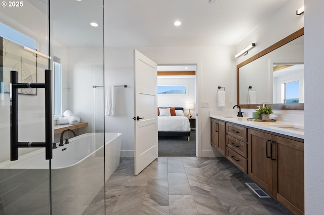 full bath with double vanity, a soaking tub, visible vents, a sink, and ensuite bath