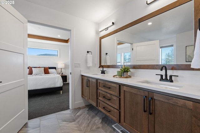 bathroom featuring double vanity, plenty of natural light, and a sink