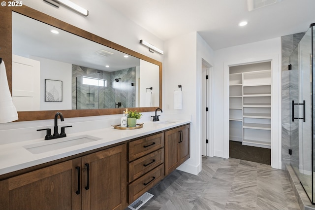 full bathroom with a spacious closet, a stall shower, and a sink