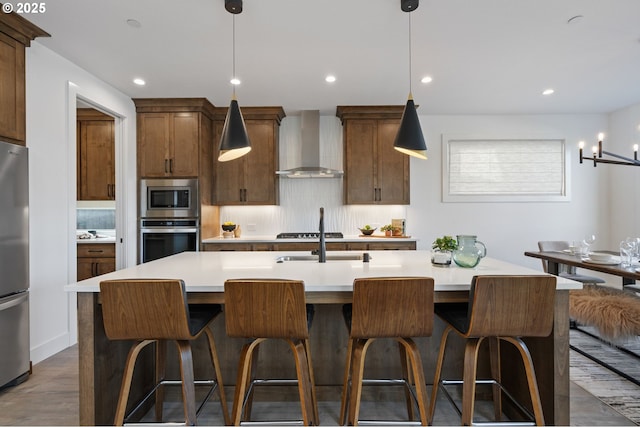 kitchen with stainless steel appliances, light countertops, wall chimney range hood, and decorative backsplash