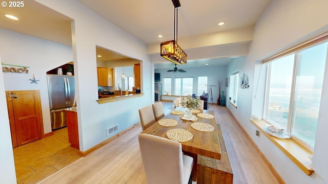 dining space with ceiling fan and light hardwood / wood-style floors