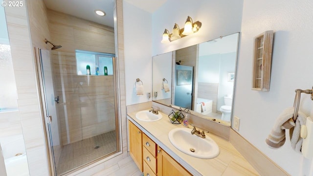 bathroom with tile patterned floors, vanity, toilet, and an enclosed shower