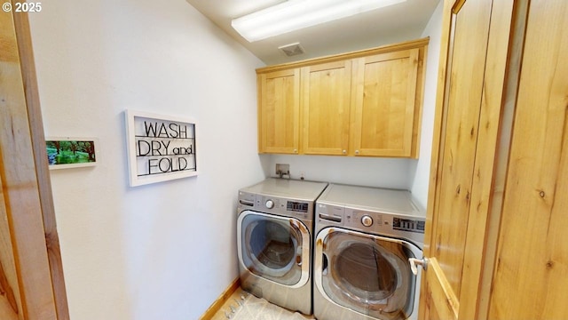 washroom featuring cabinets and washing machine and dryer