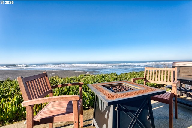 exterior space featuring a view of the beach and an outdoor fire pit