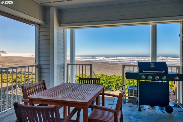 balcony with a beach view, a water view, and area for grilling