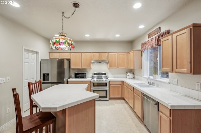 kitchen featuring pendant lighting, sink, tile countertops, and appliances with stainless steel finishes