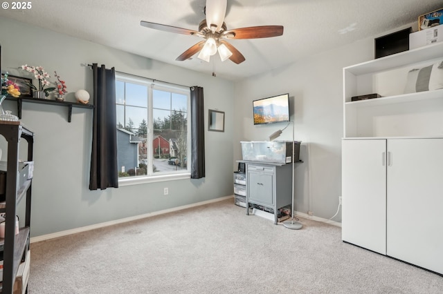 miscellaneous room featuring ceiling fan, light carpet, and a textured ceiling