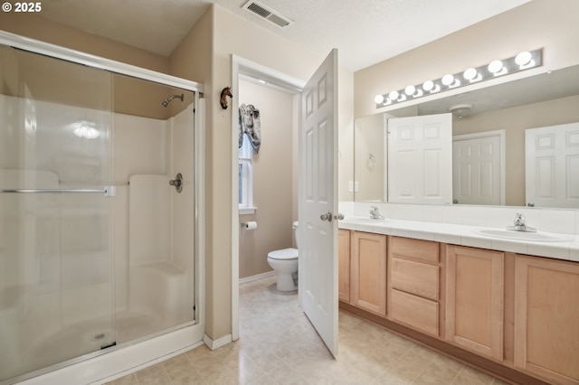 bathroom featuring walk in shower, vanity, and toilet