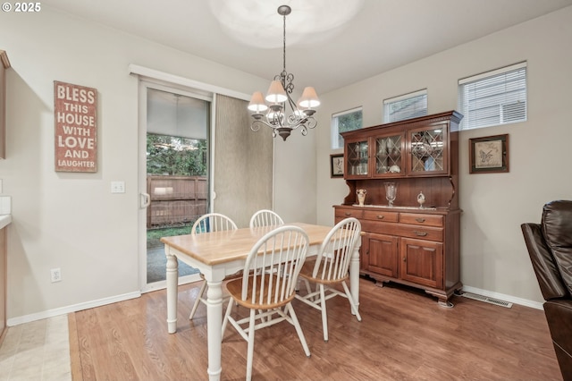 dining space with hardwood / wood-style flooring and a chandelier