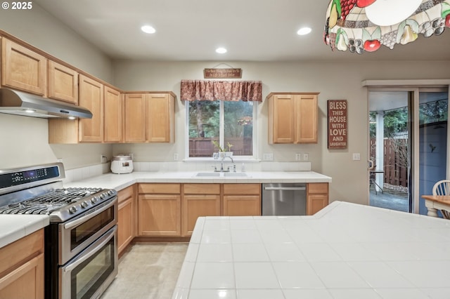 kitchen with stainless steel appliances, tile countertops, light brown cabinetry, and sink