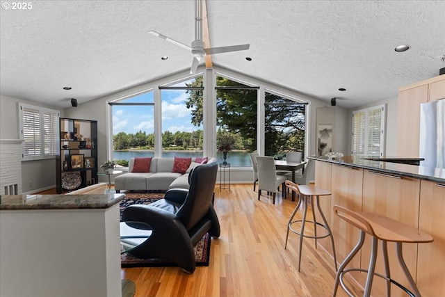21047 NE Interlachen Ln, Fairview, OR 97024 - living area featuring a textured ceiling, lofted ceiling, light wood-style floors, a water view, and ceiling fan
