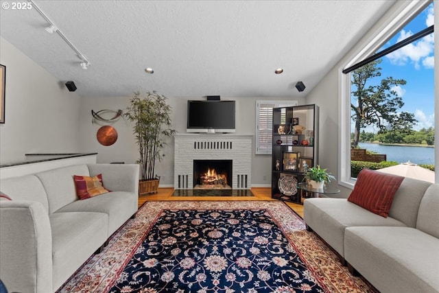 21047 NE Interlachen Ln, Fairview, OR 97024 - living area with wood finished floors, a textured ceiling, a fireplace with flush hearth, rail lighting, and recessed lighting