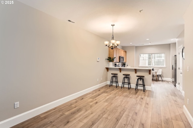 18445 SW Stepping Stone Dr Unit 16, Beaverton, OR 97003 - kitchen with a peninsula, a chandelier, a breakfast bar area, baseboards, and recessed lighting