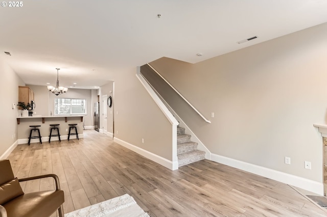 18445 SW Stepping Stone Dr Unit 16, Beaverton, OR 97003 - living area with a chandelier, baseboards, light wood-style flooring, and stairs