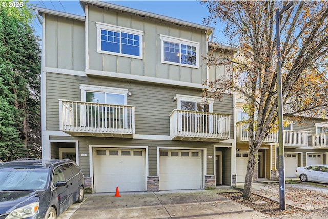 18445 SW Stepping Stone Dr Unit 16, Beaverton, OR 97003 - view of property with board and batten siding, a garage, driveway, a balcony, and stone siding