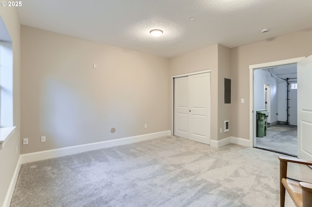 18445 SW Stepping Stone Dr Unit 16, Beaverton, OR 97003 - unfurnished bedroom featuring electric panel, a textured ceiling, light colored carpet, a closet, and baseboards