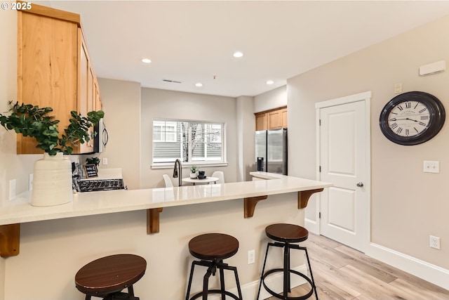 18445 SW Stepping Stone Dr Unit 16, Beaverton, OR 97003 - kitchen with stainless steel fridge, a peninsula, range, light wood-style flooring, and baseboards