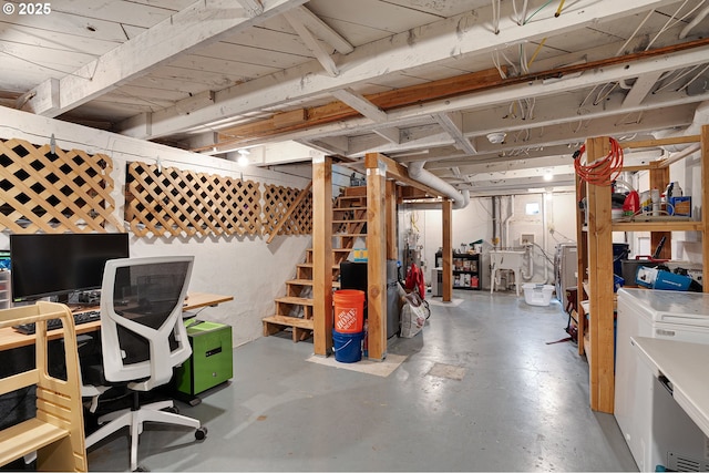 unfinished below grade area featuring washing machine and clothes dryer and stairs