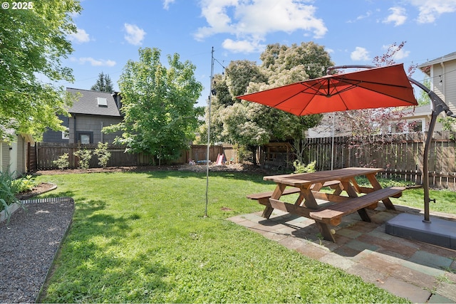 view of yard with a fenced backyard, a patio area, and outdoor dining space