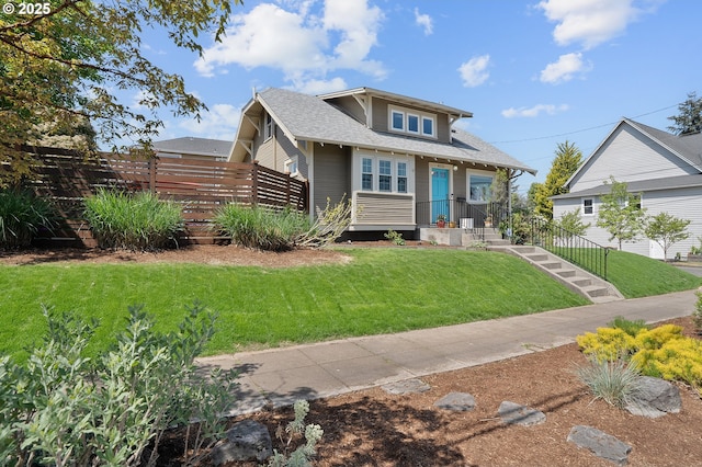 bungalow-style home featuring fence, a shingled roof, and a front yard