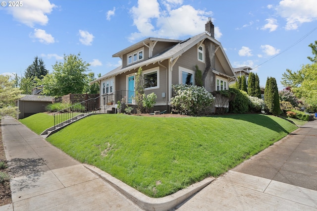view of front of house featuring a chimney and a front yard