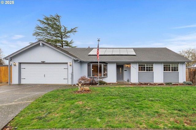 ranch-style home featuring a front yard, solar panels, and a garage