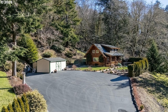 view of front of house with a porch, a shed, and a front yard