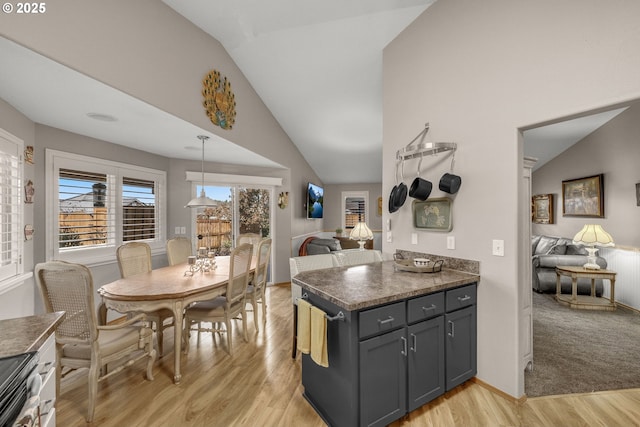 kitchen with lofted ceiling, gray cabinetry, hanging light fixtures, light wood-type flooring, and stainless steel electric stove